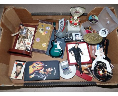 A selection of Elvis memorabilia including figures, watch in guitar box, badges and buttons, alarm clock, playing cards, wall