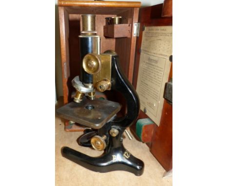 A vintage black lacquer finish laboratory bench microscope by Prior, mahogany case