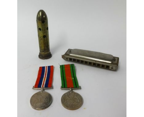 A pair of WWII medals awarded to H.E.Mitchell, Kingsbridge, boxed, also an harmonica and 'trench art' bullet.