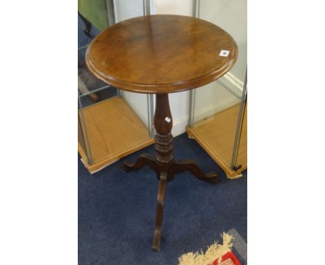 A 19th century mahogany tripod table on castors.