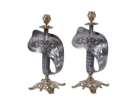 A pair of George VI sword guard brass and steel candlesticks, assembled first half 20th century, the brass quadripartite base