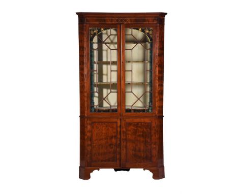 A George III mahogany standing corner cabinet, circa 1780, the astragal glazed doors enclosing a proscenium arch with gilt vi