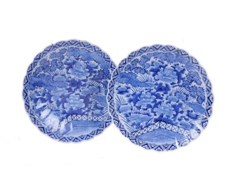 A pair of Arita porcelain blue and white fluted chargers with scalloped rims, first quarter 20th century, painted with flower