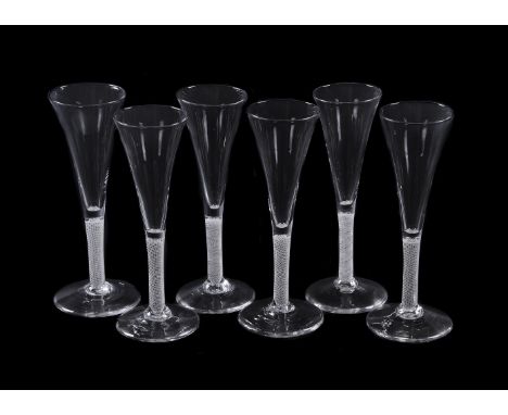 Six similar opaque-twist wine flutes, circa 1760, of drawn trumpet form, the stems filled with spiral threads, on conical fee