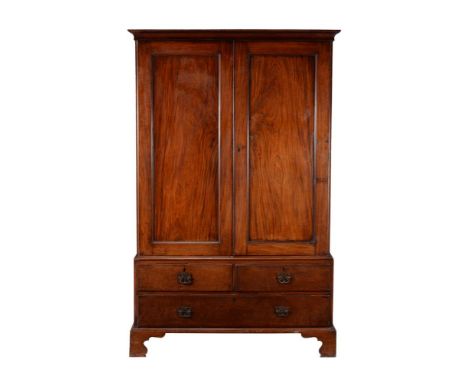 A George III mahogany clothes press, circa 1780, the doors opening to three sliding trays, 199cm high, 127cm wide, 58.5cm dee