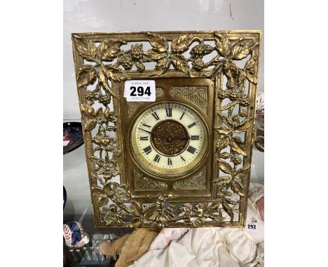 A BRASS EASEL BACK DESK CLOCK IN A FLORAL DECORATED OPEN WORK FRAME WITH BALANCE WHEEL ESCAPEMENT. 