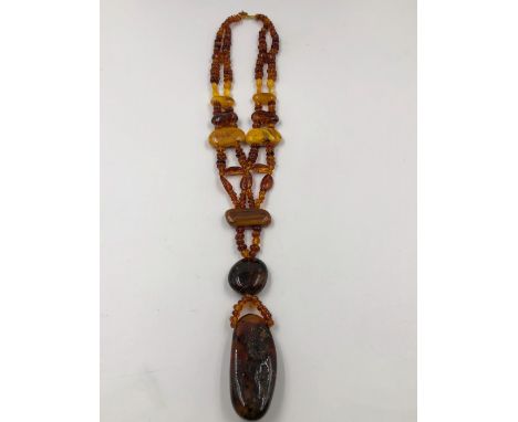 A VINTAGE MULTI COLOUR  AMBER NECKLACE WITH LARGE NATURAL AMBER STRUNG PENDANT. LENGTH 54cms, WEIGHT 76grms. 