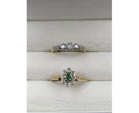 A 9ct HALLMARKED EMERALD AND DIAMOND CLUSTER RING, TOGETHER WITH AN 18ct GOLD AND PLATINUM THREE STONE DIAMOND VINTAGE RING. 