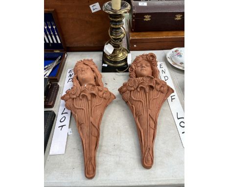 A BRASS TWO LIGHT CANDLESTICK TABLE LAMP TOGETHER WITH TWO TERRACOTTA WALL CORNUCOPIA CRESTED BY ART NOUVEAU LADYS HEADS