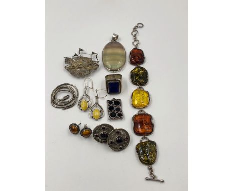 AN ACCUMULATION OF VARIOUS SILVER JEWELLERY TO INCLUDE A MULTI AMBER BRACELET, A LARGE HARDSTONE OVAL PENDANT, A SHIP BROOCH,