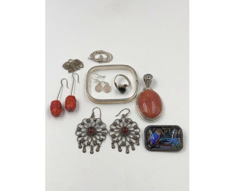 A COLLECTION OF SILVER JEWELLERY TO INCLUDE A HINGED BANGLE, A LARGE RED HARDSTONE OVAL PENDANT, THREE PAIRS OF VARIOUS EARRI