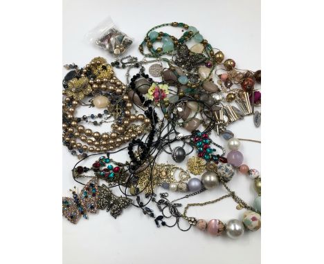 A COLLECTION OF COSTUME JEWELLERY TO INCLUDE EARRINGS, BEADS, CHAINS, CERAMIC FLORAL BROOCH ETC. 