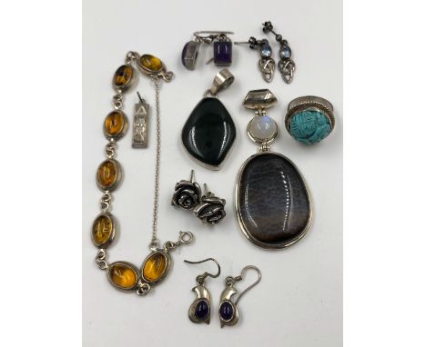 A COMBINATION OF VARIOUS SILVER JEWELLERY TO INCLUDE HARDSTONE PENDANTS, A CARVED TURQUOISE RING, ROSE EARRINGS, AMBER BRACEL