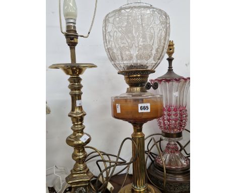 A CRANBERRY GLASS OVERLAY TABLE LAMP, A BRASS TABLE LAMP AND AN OIL LAMP