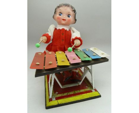 A clockwork toy, girl playing a xylophone