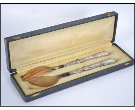 A silver handled early 20th century bone serving spoon and fork set being unmarked, tests as silver. Complete in the original
