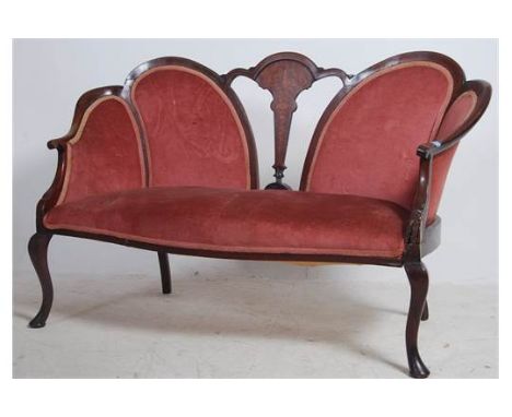 An Edwardian mahogany inlaid spoon back conversation sofa settee having shaped legs with pad feet. Pink velour upholstered se