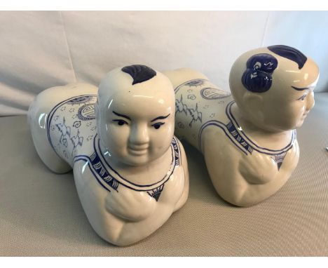 2 Ceramic oriental blue and white children shaped foot stools. Measure 22x34x14cm each 