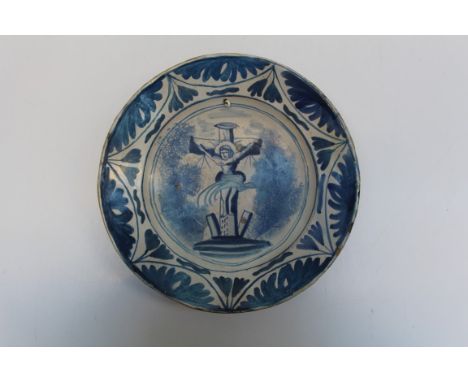 An 18th century Delftware large plate depicting the crucifixion, restored and drilled, diameter 30.5cm&nbsp;