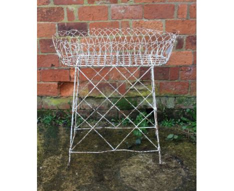 A painted metalware planter of openwork form raised on tall supports, width 78cm