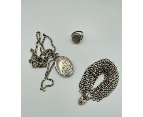 A collection of silver jewellery comprising a locket and chain, a poison ring and a padlock clasped five row chain bracelet. 