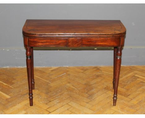 A George III mahogany, ebony strung card table with fold over top, raised on turned tapering legs, 90cm wide