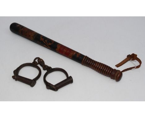 A late 19th / early 20th century painted police constable's truncheon, together with a pair of iron handcuffs, length 43cm  F