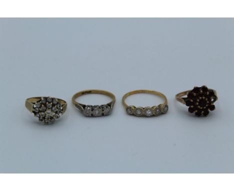 A collection of four dress rings. To include two 9ct gold cluster rings, one set with cubic zirconia, the other set with garn