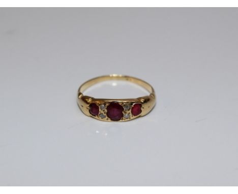 An Edwardian three stone ruby ring. The principal stone approximately 3 x 5mm to a gold shank. Gross weight 2gm. Ring size O