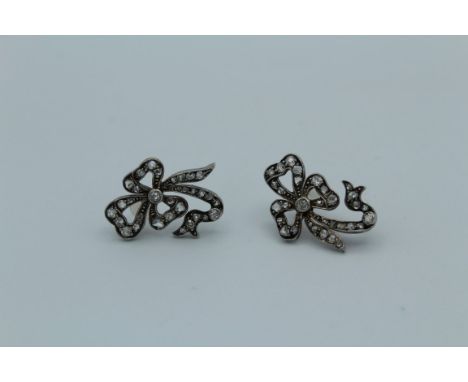 A pair of Victorian rhodium plated, silver and gold, diamond set bow form earrings. Maximum length 23mm. Gross weight 4gm&nbs