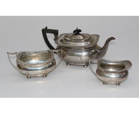 James Deakin and Sons, a George V silver three piece tea service, comprising pot with ebonised fittings, twin handled sugar a