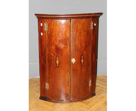 A George III mahogany, boxwood strung and inlaid bow front wall mounting corner cupboard with three shelves, 100 x 73 x 49cm