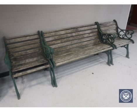 A wrought iron and wood three piece garden furniture set comprising bench and two armchairs