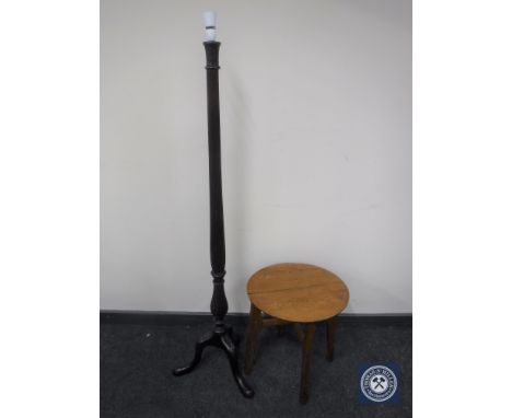A carved mahogany standard lamp on tripod base together with a circular oak occasional table