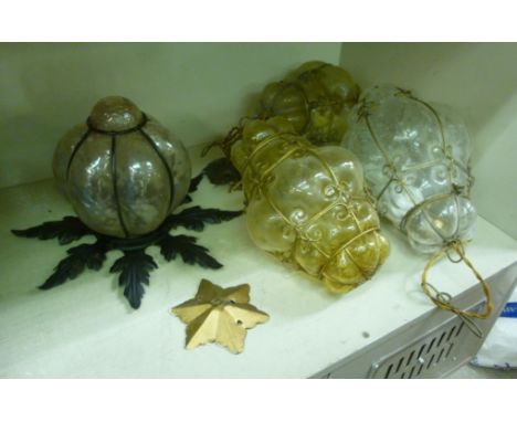 Four similar, variously coloured, moulded glass pendant light shades in scrolled wire frames       OS10