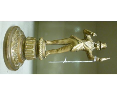 A late Victorian cast brass novelty cigar lighter, fashioned as a standing man, holding a bottle aloft, on a circular plinth 