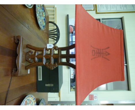 A modern Oriental polished and carved hardwood table lamp, on a platform base  17''h with a box design red fabric shade      