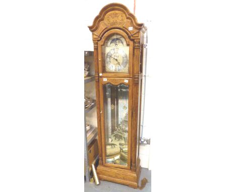 LONG CASE CLOCK. Westminster chime oak long case clock with weights and pendulum by Howard Miller