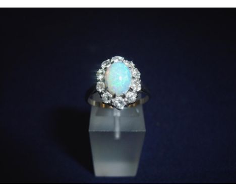 Platinum diamond and opal flower head ring with large central raised opal within a border of ten diamonds (ring size R) 