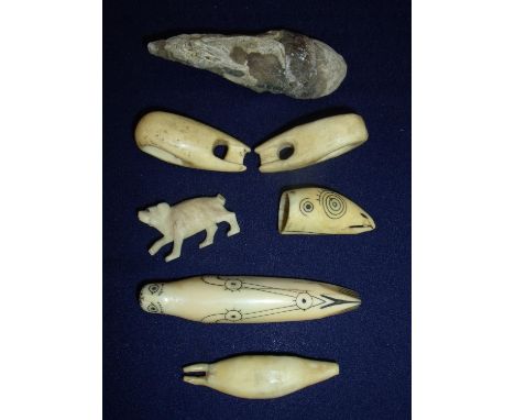 Collection of interesting Inuit type carved bone items and a stone fossil including a carved bone figure of a seal with inked