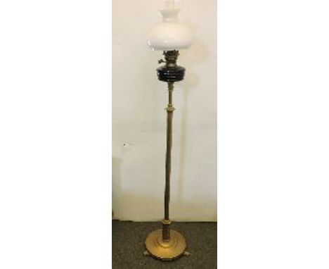 An Edwardian brass standard lamp, with blue glass reservoir and white shade