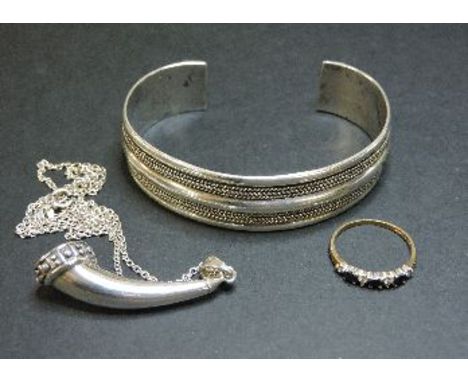 A 9ct gold sapphire and diamond half hoop ring, a silver torque bangle, and a silver horn pendant