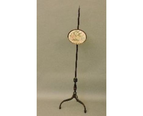 A George III pole screen, with an oval embroidered panel of flowers in a basket, 151cm high