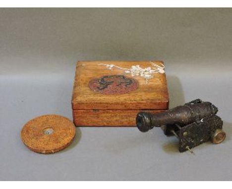 A Chinese wooden box, with applied lacquered dragon cartouche and ivory prunus, a Chinese hardstone model of a cannon, and a 