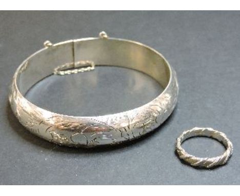 An 18ct white gold twisted band ring, and a silver bangle marked 925