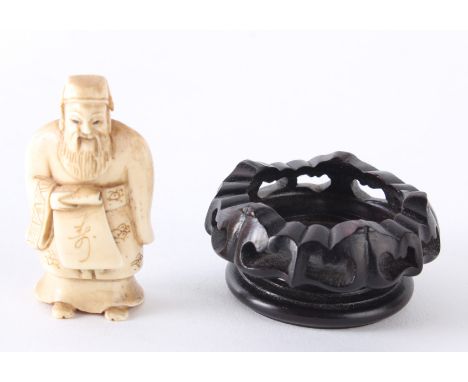 An ivory netsuke of a sage, an ivory netsuke of figures with stand