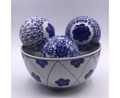 Four blue and white ceramic balls and a bowl 