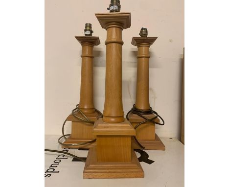 A Set of three wooden pillar style candlesticks
