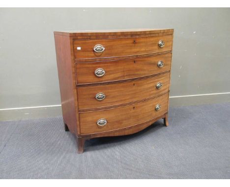 A George III mahogany and walnut cross-banded bowfront chest of drawers, with oval embossed brass bail handles, on slender br