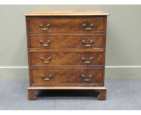 A Georgian style mahogany cabinet, the rectangular hinged top over two fall front compartments hidden by a four faux drawer f